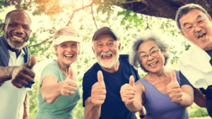 a group of seniors smiling with thumbs up