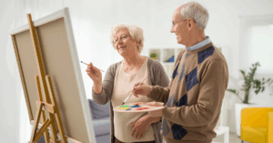 a senior couple painting on a canvas
