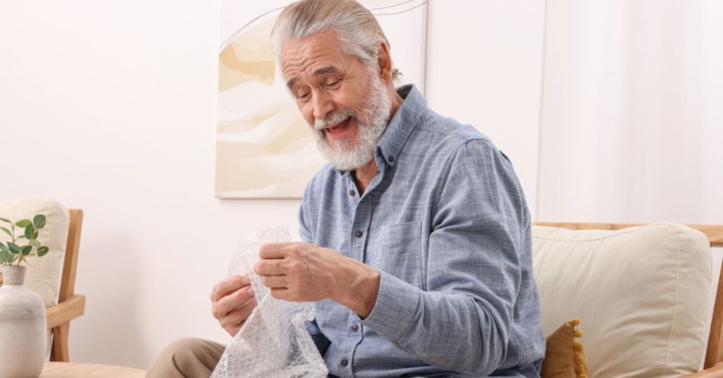 a man smiling while holding a plastic bag