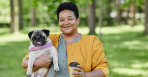 a senior lady carrying her puppy